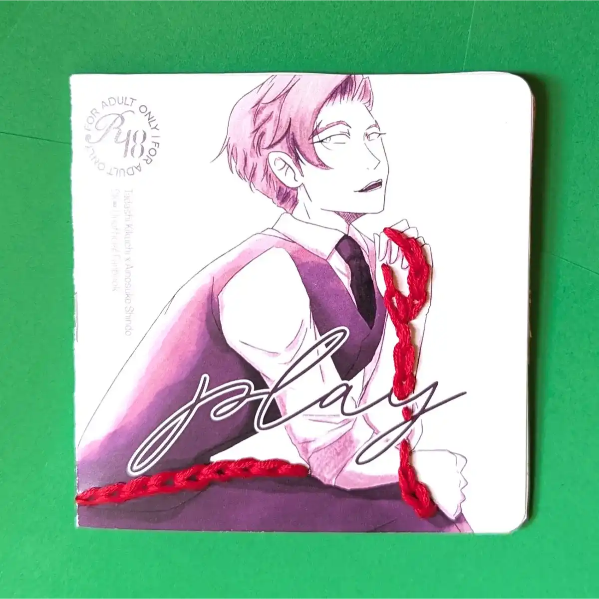 Play zine cover featuring a man holding a red leash. The leash is made of embroidery floss.